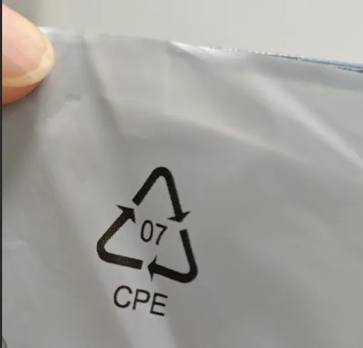 The triangular recycling mark and the letters CPE printed in black on a matt grey film bag