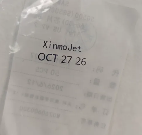 A black wordmark and date code printed on a clear PE/PP film sample, with reversed print from the far side visible through the film
