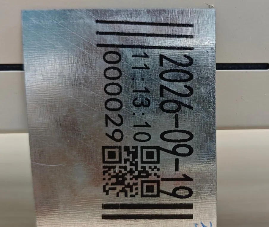 A date, a time and a running count printed vertically along a brushed tinplate strip, with a barcode above them