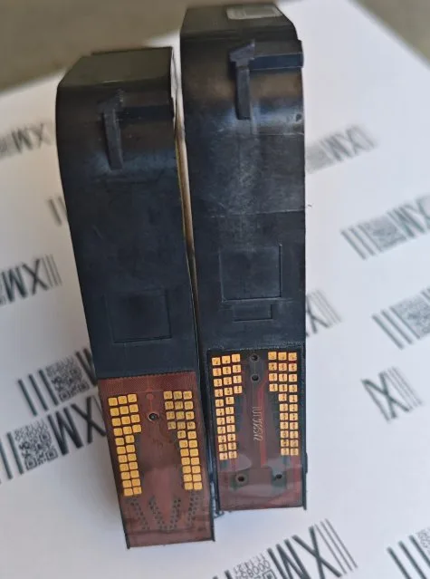 The same two cartridges turned over, showing the gold electrical contact pads that mate with the printhead